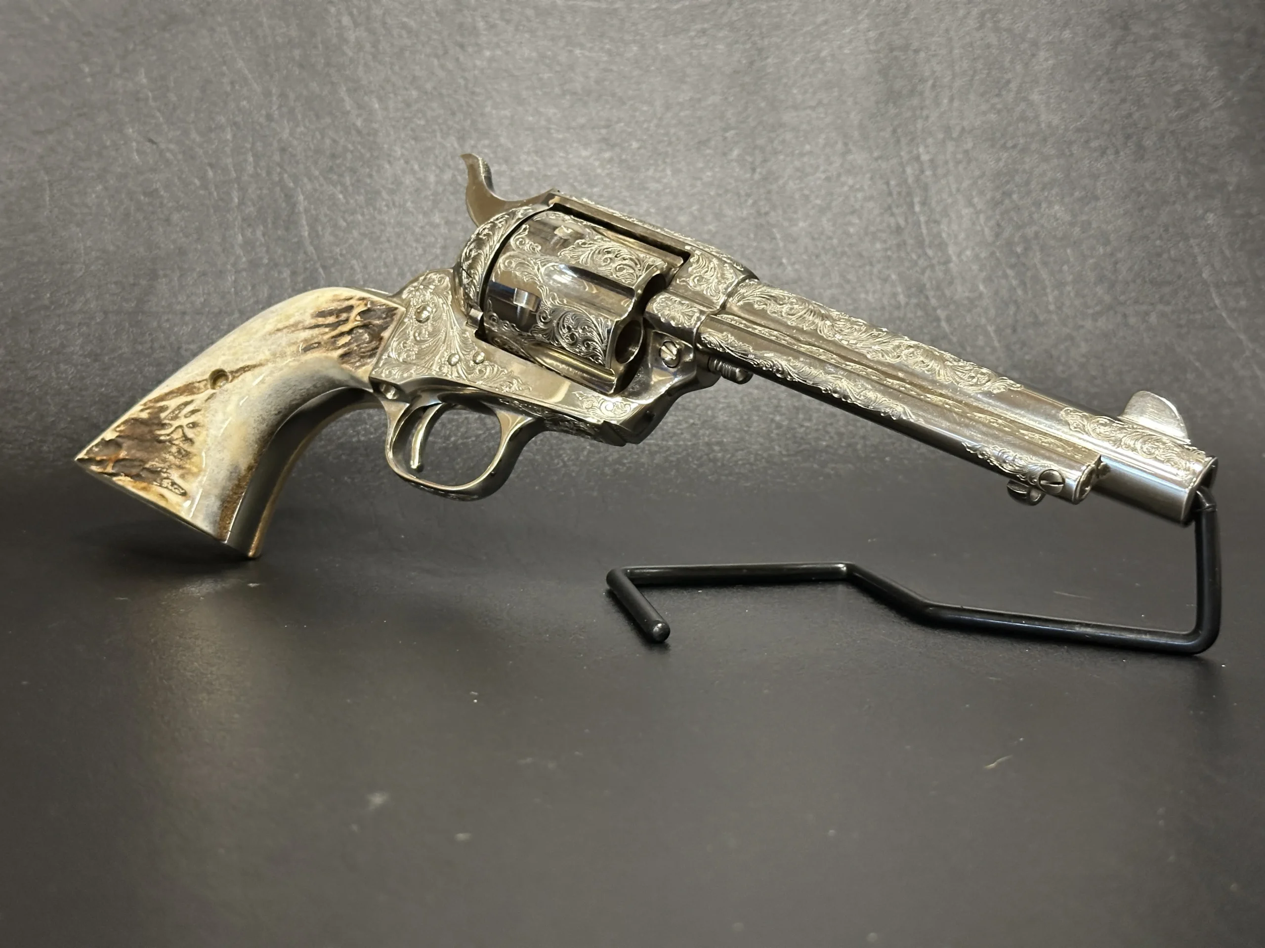 Colt Single Action Army Factory Engraved Nickel firearm shown in close-up detail